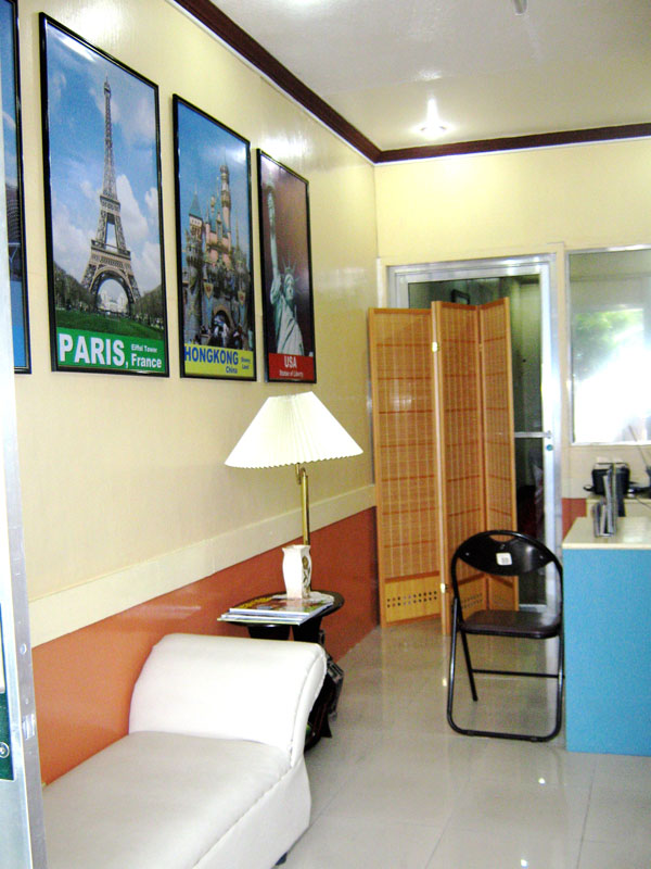 An office with travel posters of Paris and other cities, a white lounge chair and a counter