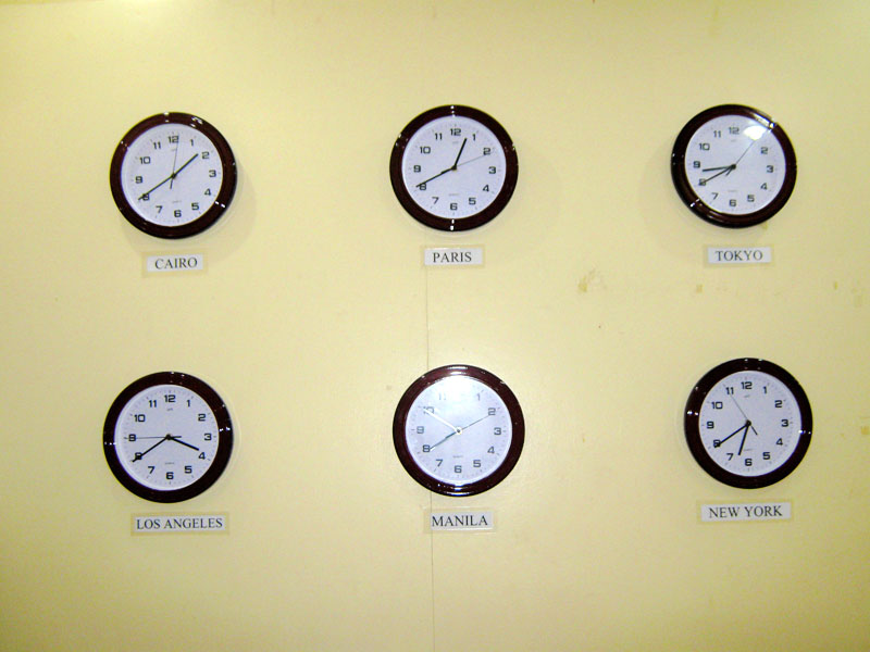 Six wall clocks set to the time in cities around the world