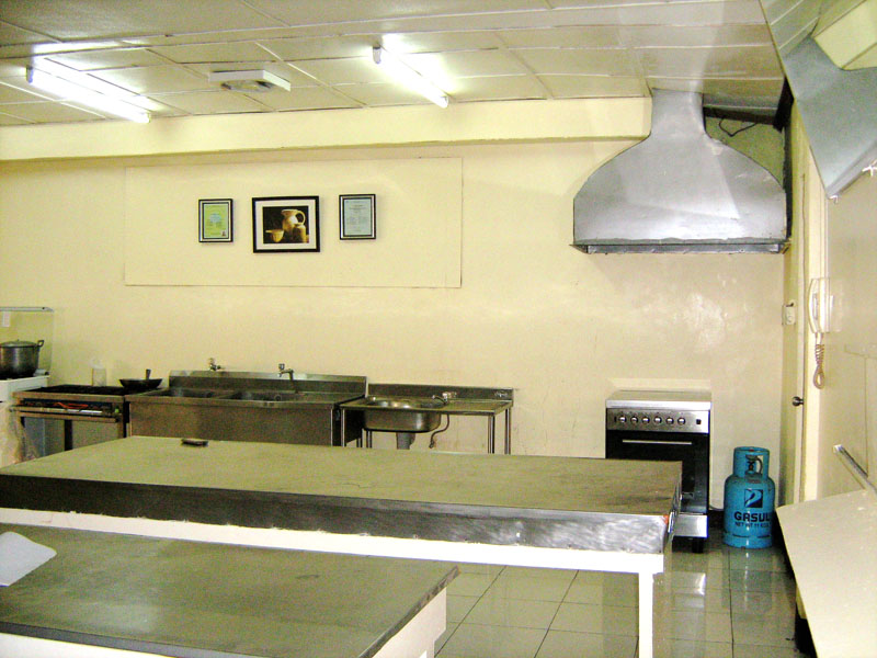 A kitchen with stainless steel counters and a range hood
