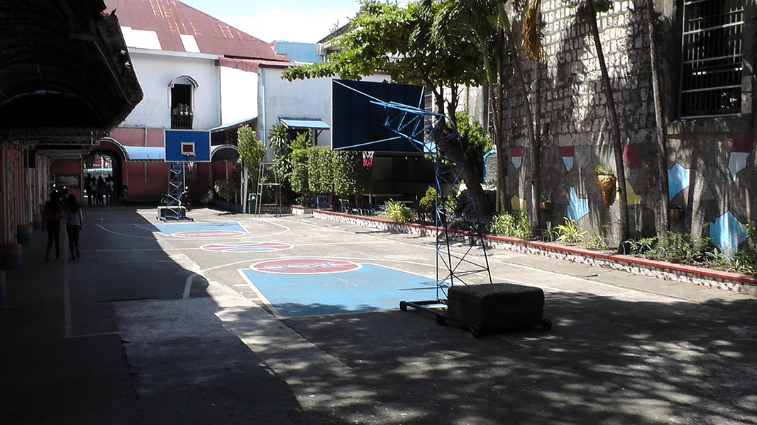 The school grounds with a basketball court and a covered walkway