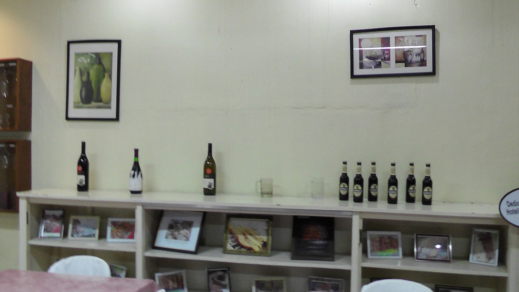 Shelves displaying wine bottles and framed pictures