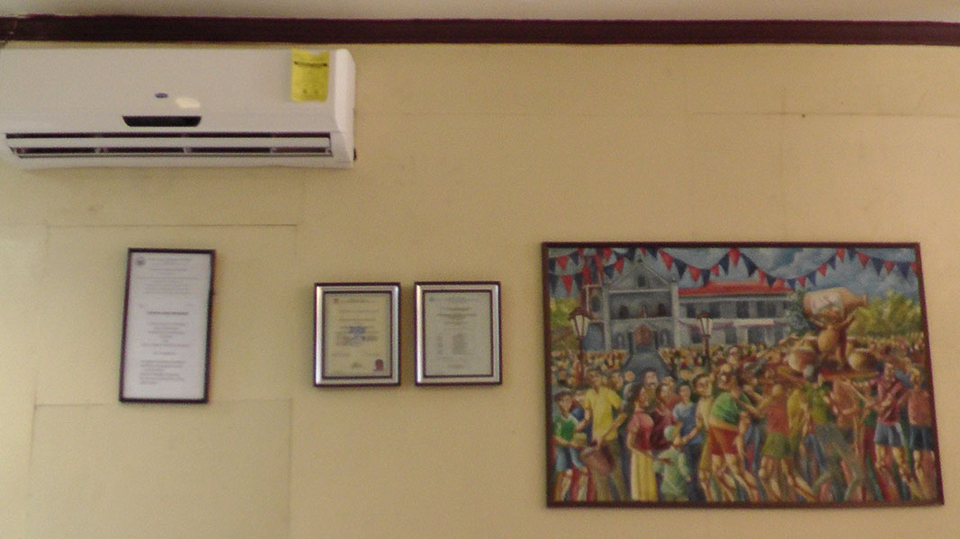 Framed certificates and a painting on a wall